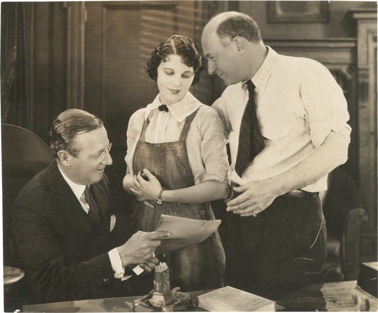 [Book #151930] Original press photograph of Leatrice Joy being presented a "star contract" by Cecil B. DeMille and Jesse L. Lasky, 1924. Cecil B. DeMille, Leatrice Joy, Jesse L. Lasky, subjects.