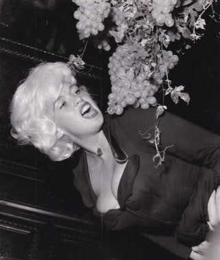Book #155640] Original photograph of Jayne Mansfield eating grapes at a party in Berlin, circa...