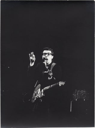 Book #159118] Collection of three original photographs of Elvis Costello onstage, circa 1980s....