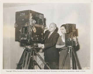 Book #160636] Original photograph of Cecil B. DeMille with two film cameras, circa 1932. Emily...