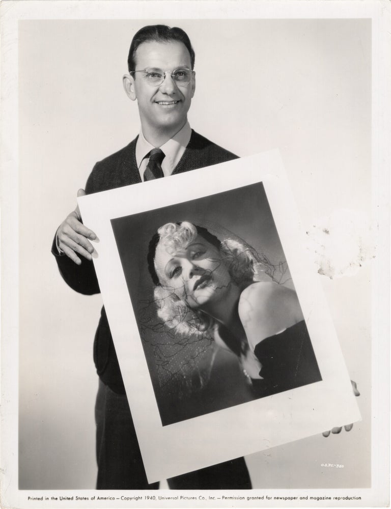 Book #165555] Original photograph of photographer Ray Jones holding a portrait of Marion Martin....